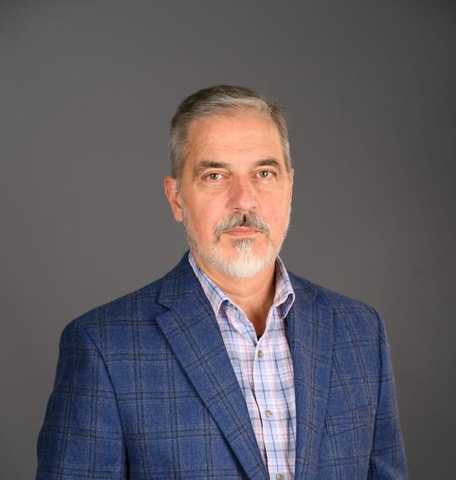 Daniel Huck Portrait with grey background.