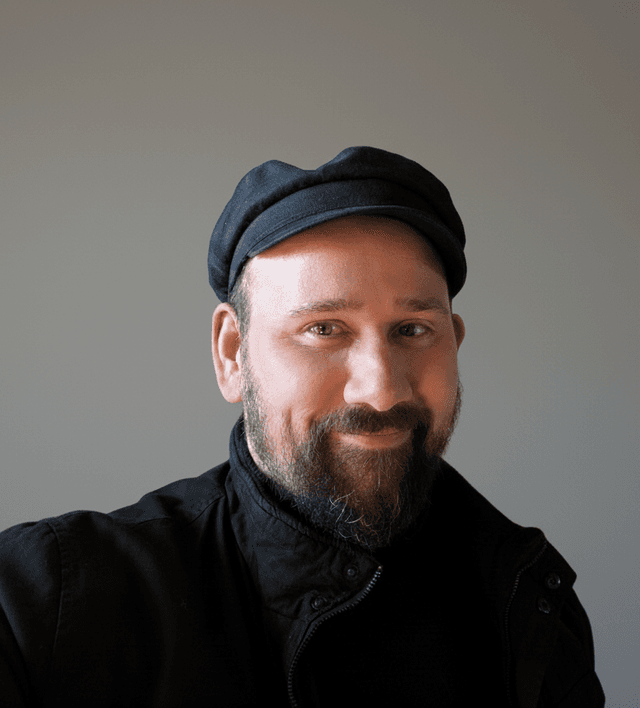 Jamie O'Brien picture of himself in a black top and a black hat smiling at the camera
