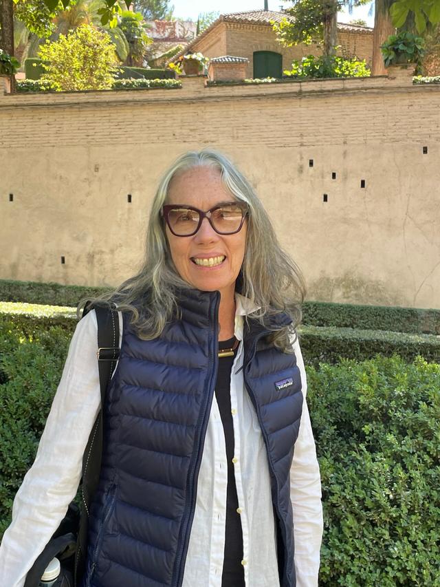 Marguerite Rivage-Seul, picture smiling at the camera with a colorful background.