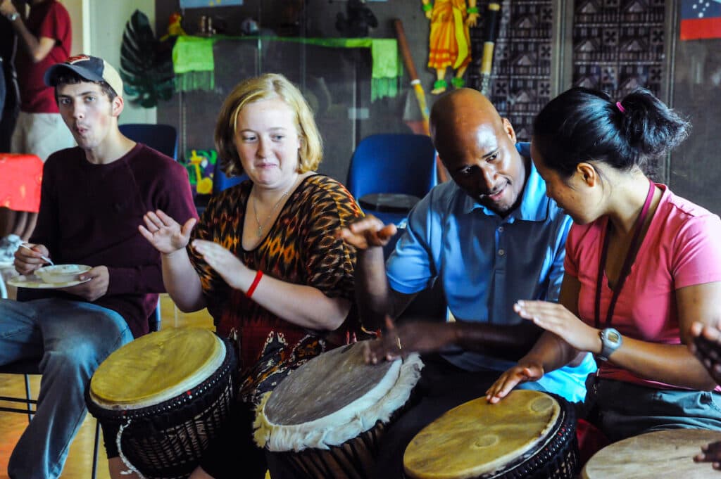 Think Globally It's Friday meeting with students and staff playing African drums