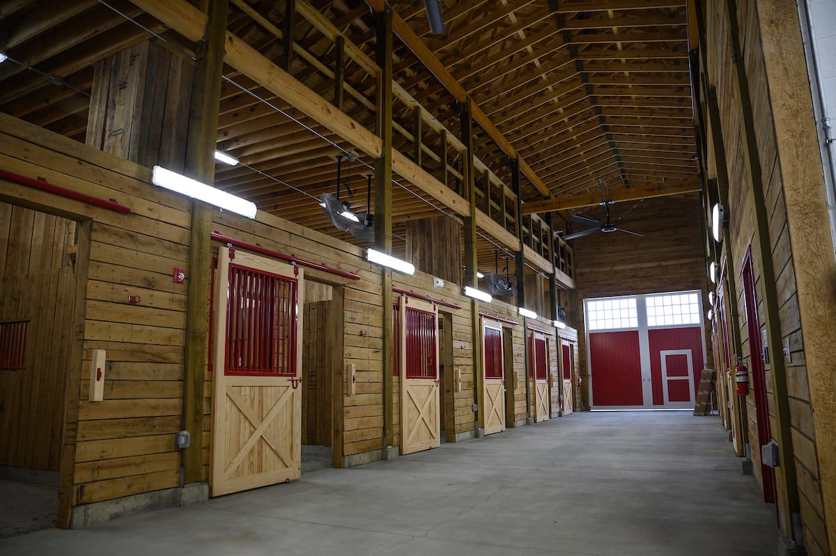 A picture of the inside of the new horse barn. The picture features the main entryway to the barn as well as several stable doors.