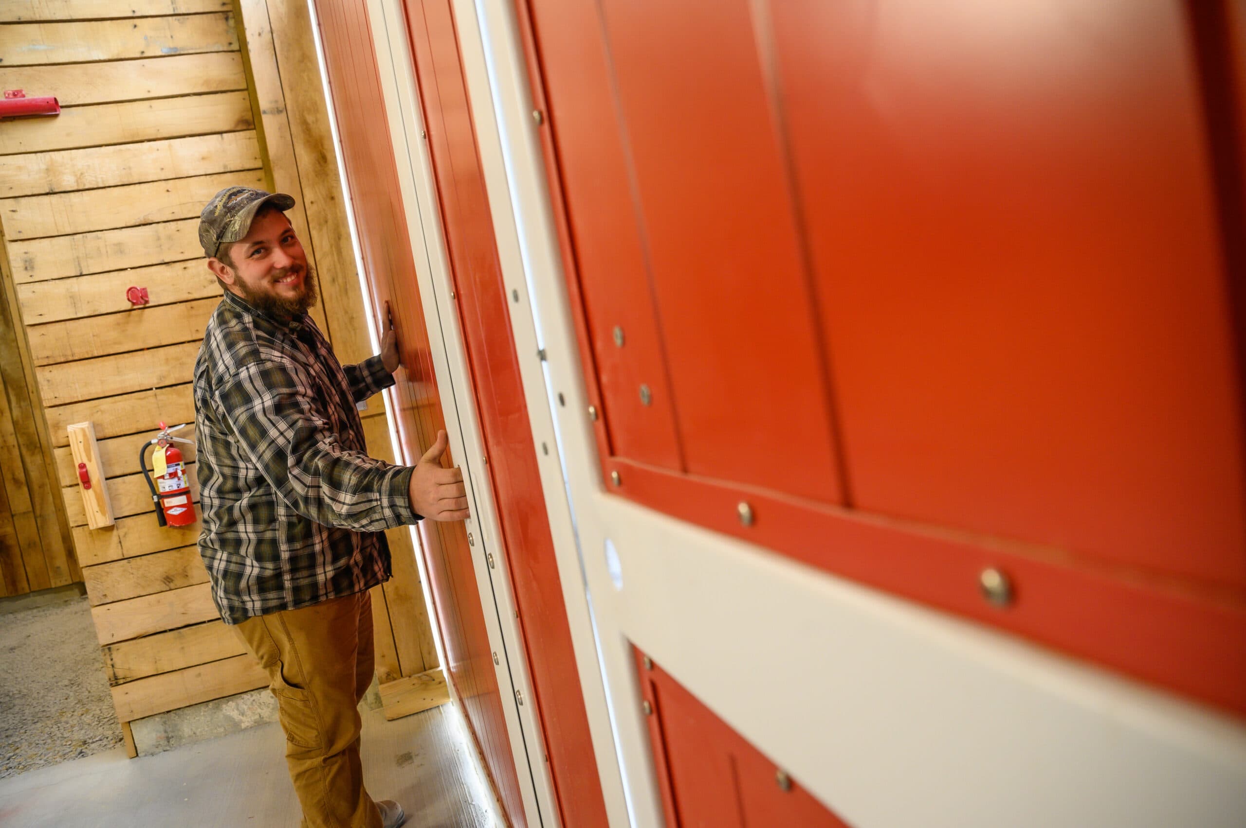 Berea College Forestry employee, John Hite '19 closing one of the horse stable doors.