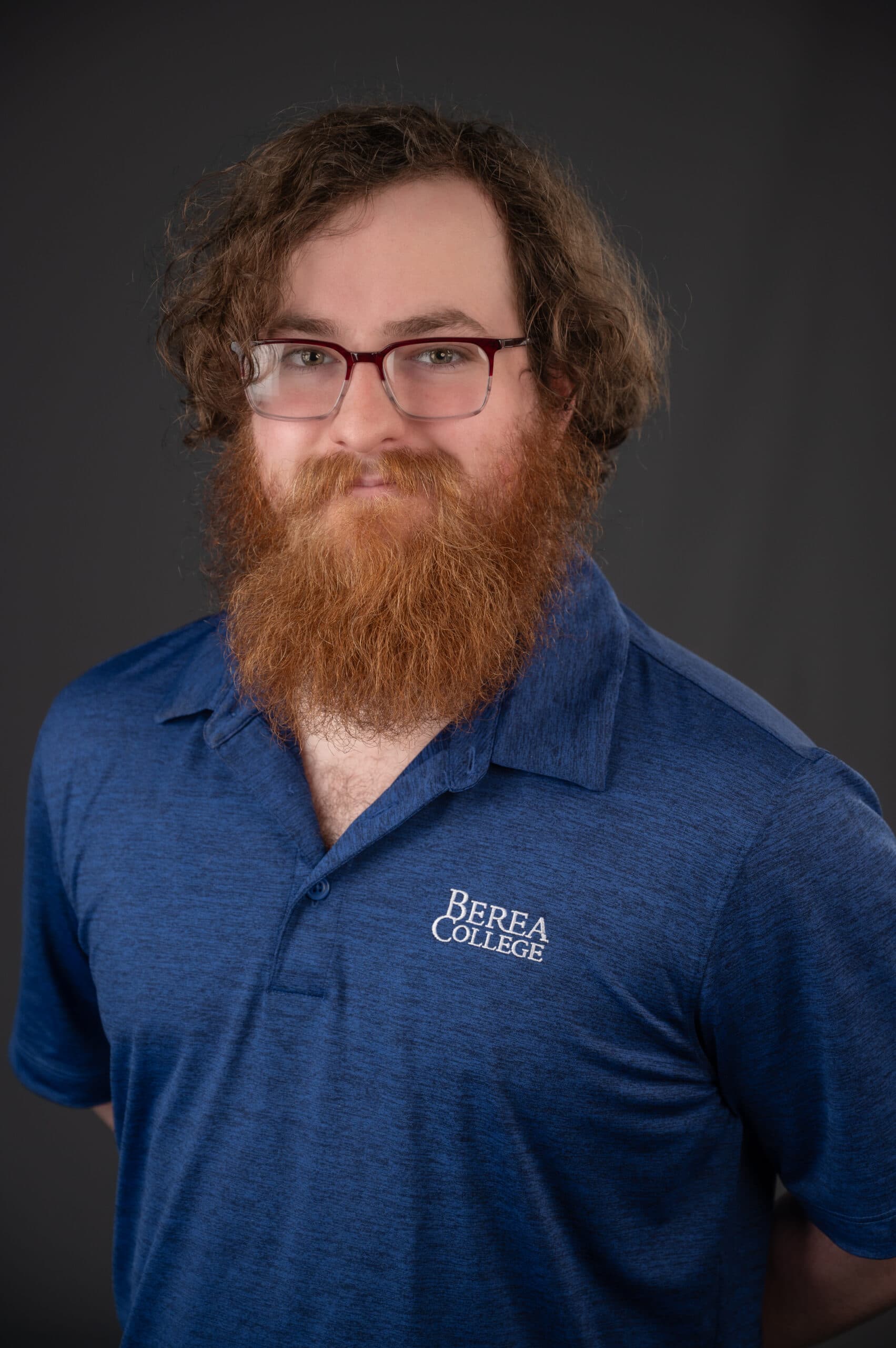 Zachary Scott portrait wearing a blue shirt with a grey background