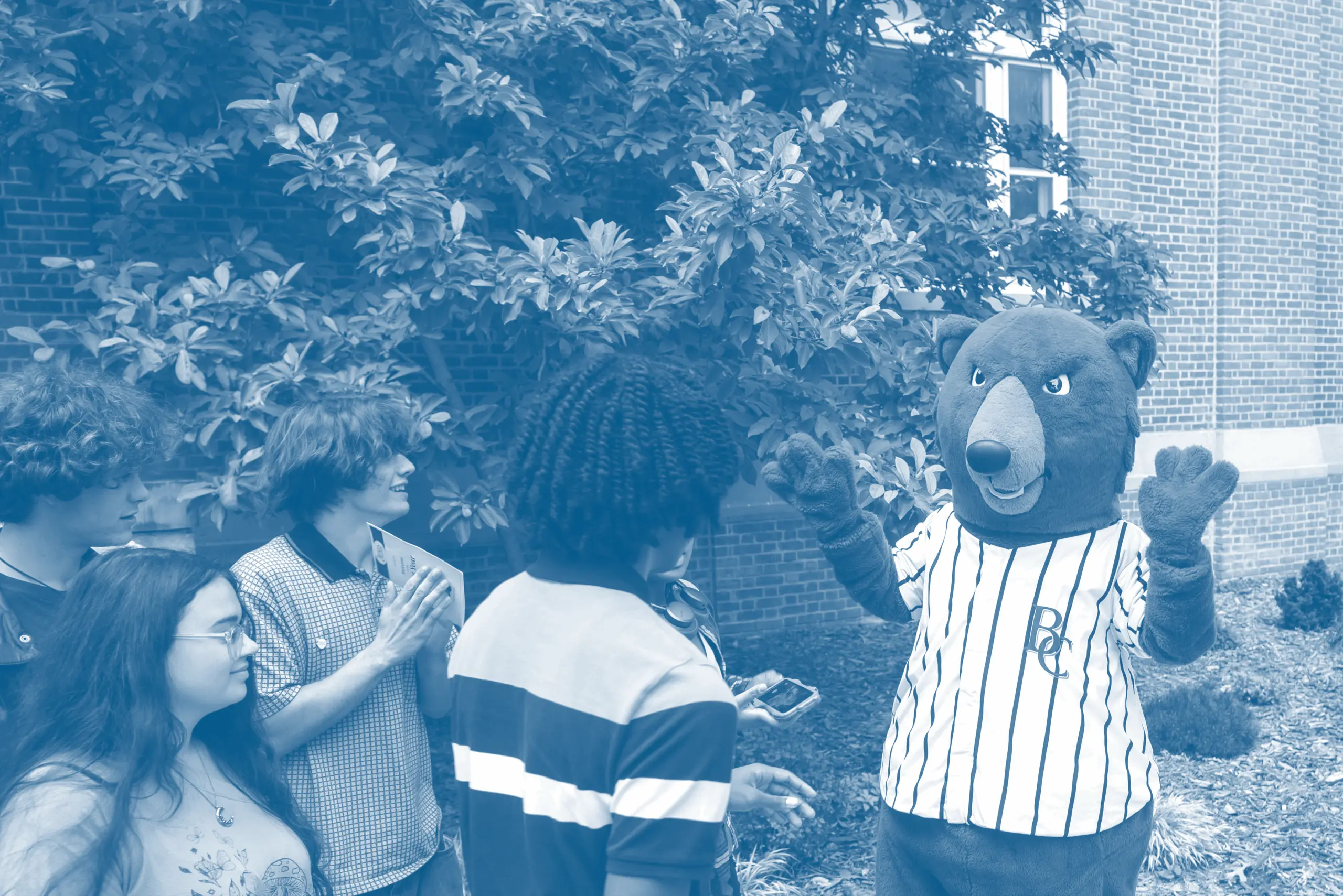 Berea's mascot, Blue the bear, greeting a group of students.